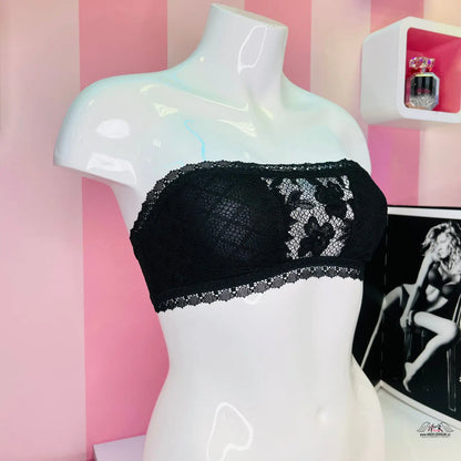 Manekýn s černou podprsenkou před růžově pruhovanou stěnou Elegance a smyslnost