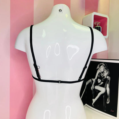 Arafed mannequin in black bra against a pink striped wall highlighting Elegantní Braletka