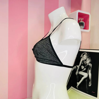 Muž s černým braletem před růžovo-bílou pruhovanou zdí v elegantním stylu