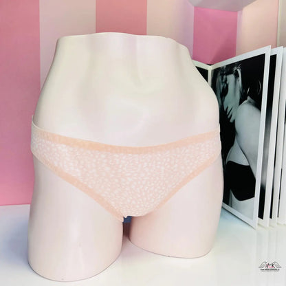 Bílý mannequin s růžovým podprsenkou před růžově pruhovanou zdí