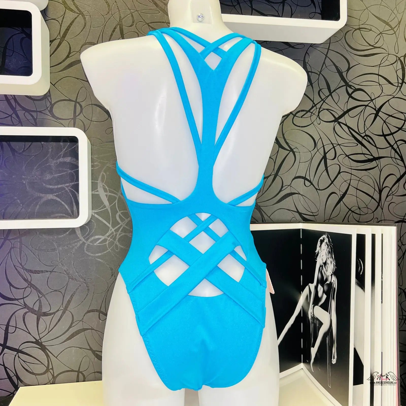 Modré plavky Keia s propracovaným strappy designem na bílém manekýnu