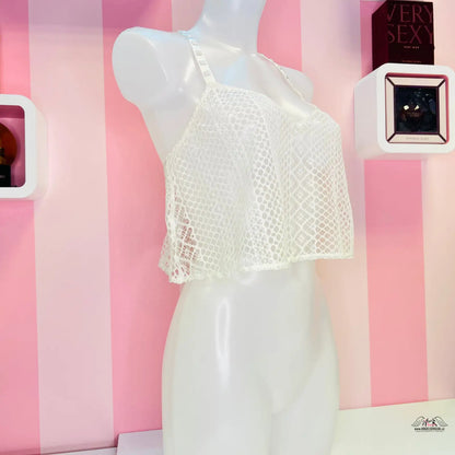 Bílý krajkový crop top vystavený na manekýně pro elegantní vzhled