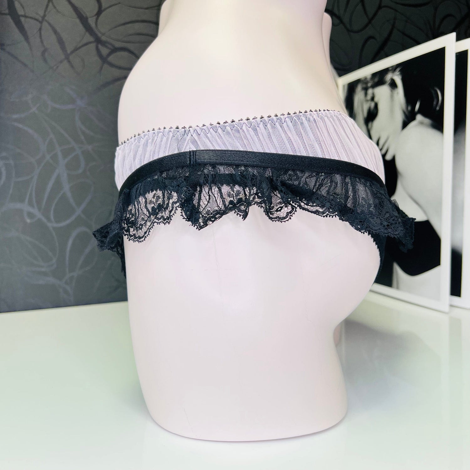 Lace-trimmed kalhotky Fifi s krajkovými volánky a černou mašličkou na manekýnu