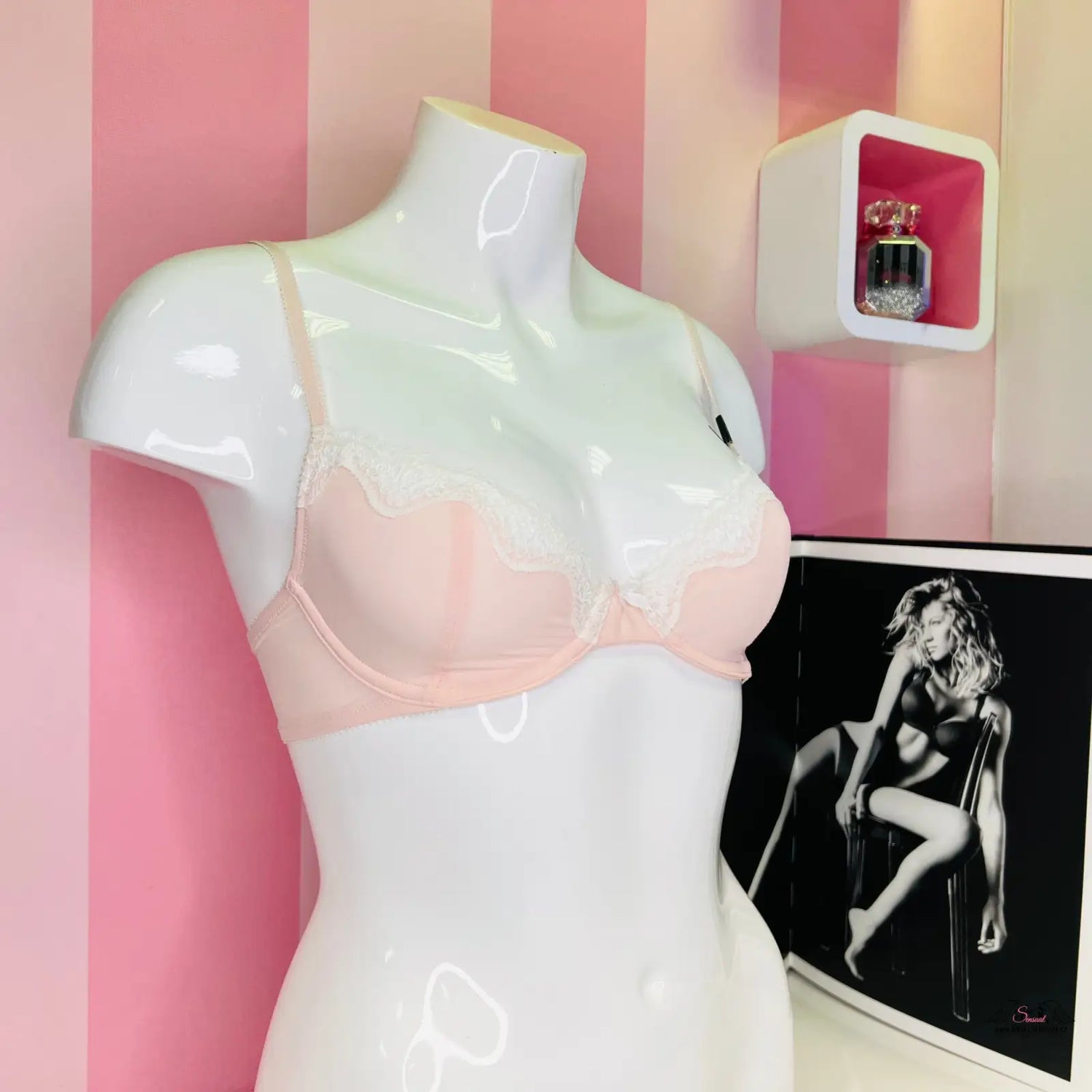 Mannequin wearing pink bra with black and white photo of Luxusní Krajková Podprsenka