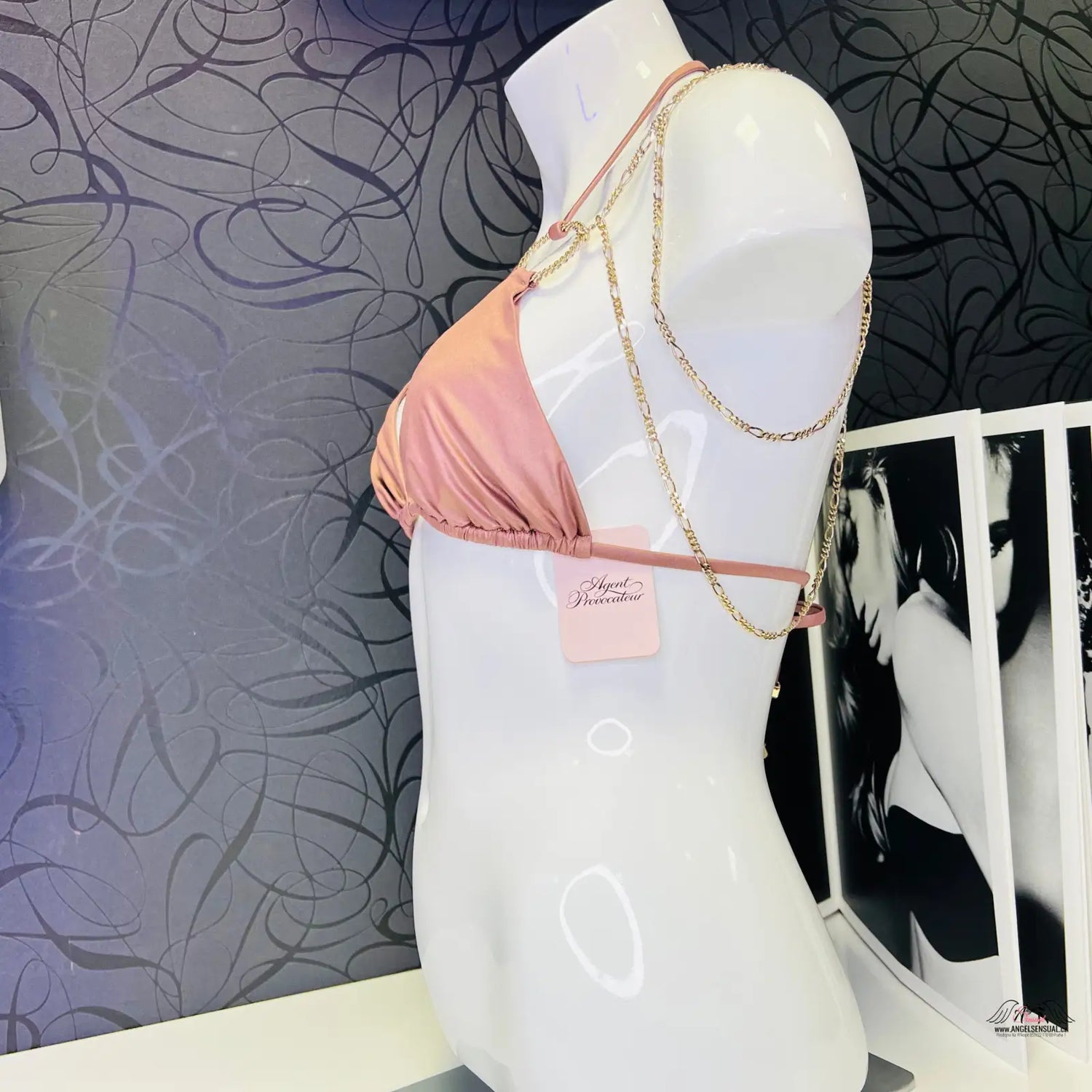 Růžový bikini top na bílém figuríně s luxusními zlatými ozdobami