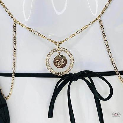 Zlatý náhrdelník s kruhovým přívěskem a monogramem ozdobený rhinestones
