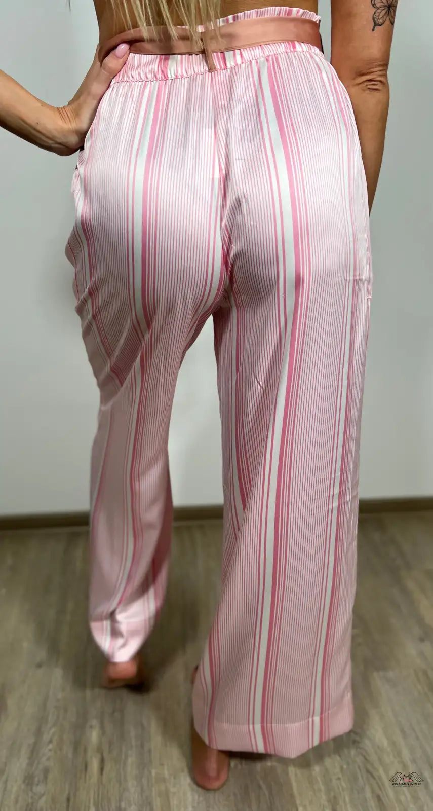 Žena v pruhovaných kalhotách z luxusního saténu pro elegantní relaxaci