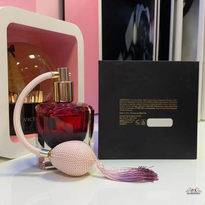 Lahvička parfému vedle krabičky Luxusní Vůně od Victoria’s Secret elegance