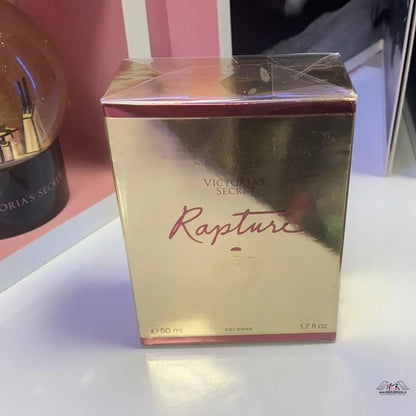 Detailní záběr na parfém Neodolatelná Elegance Rapture na stole