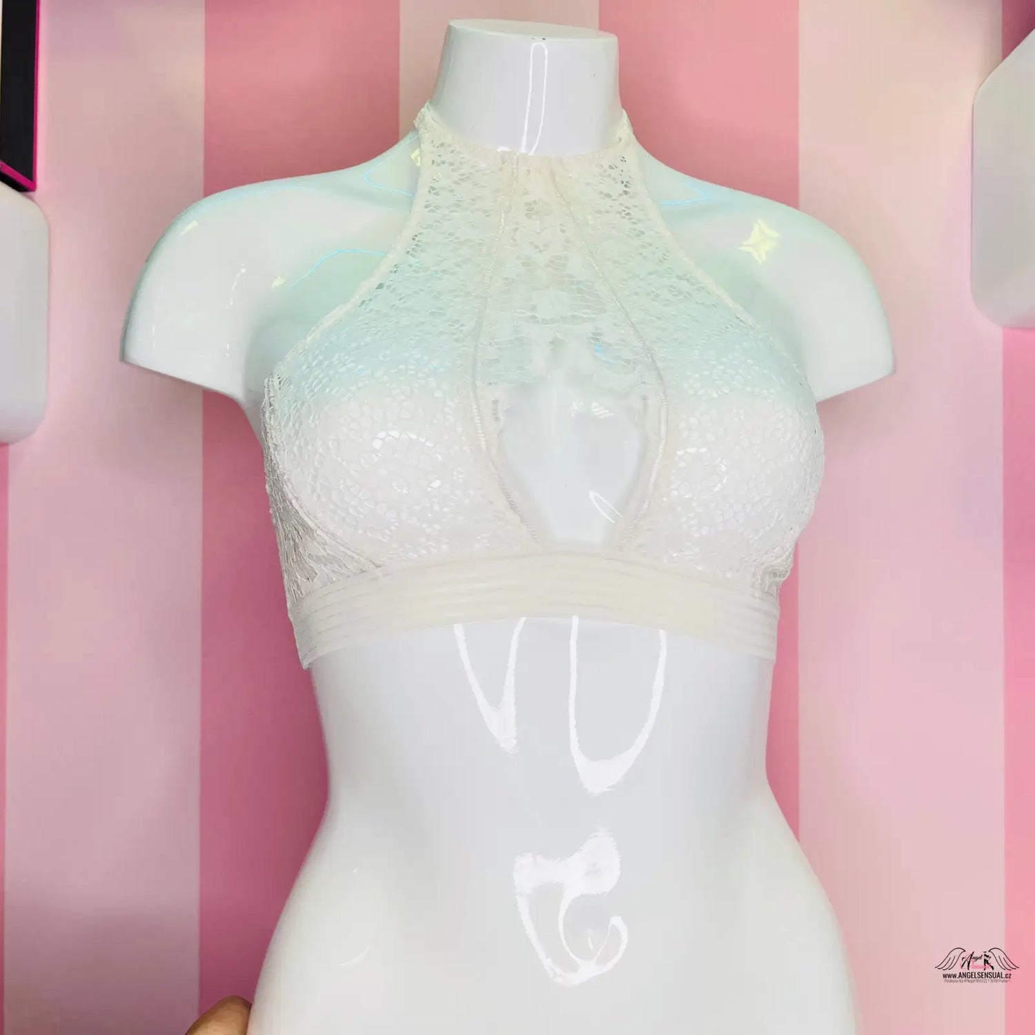 Manekýn s bílou podprsenkou na růžově pruhované zdi Victoria’s Secret