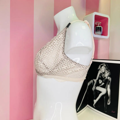 Bílá manekýnka vystavující krajkovou podprsenku od Victoria’s Secret