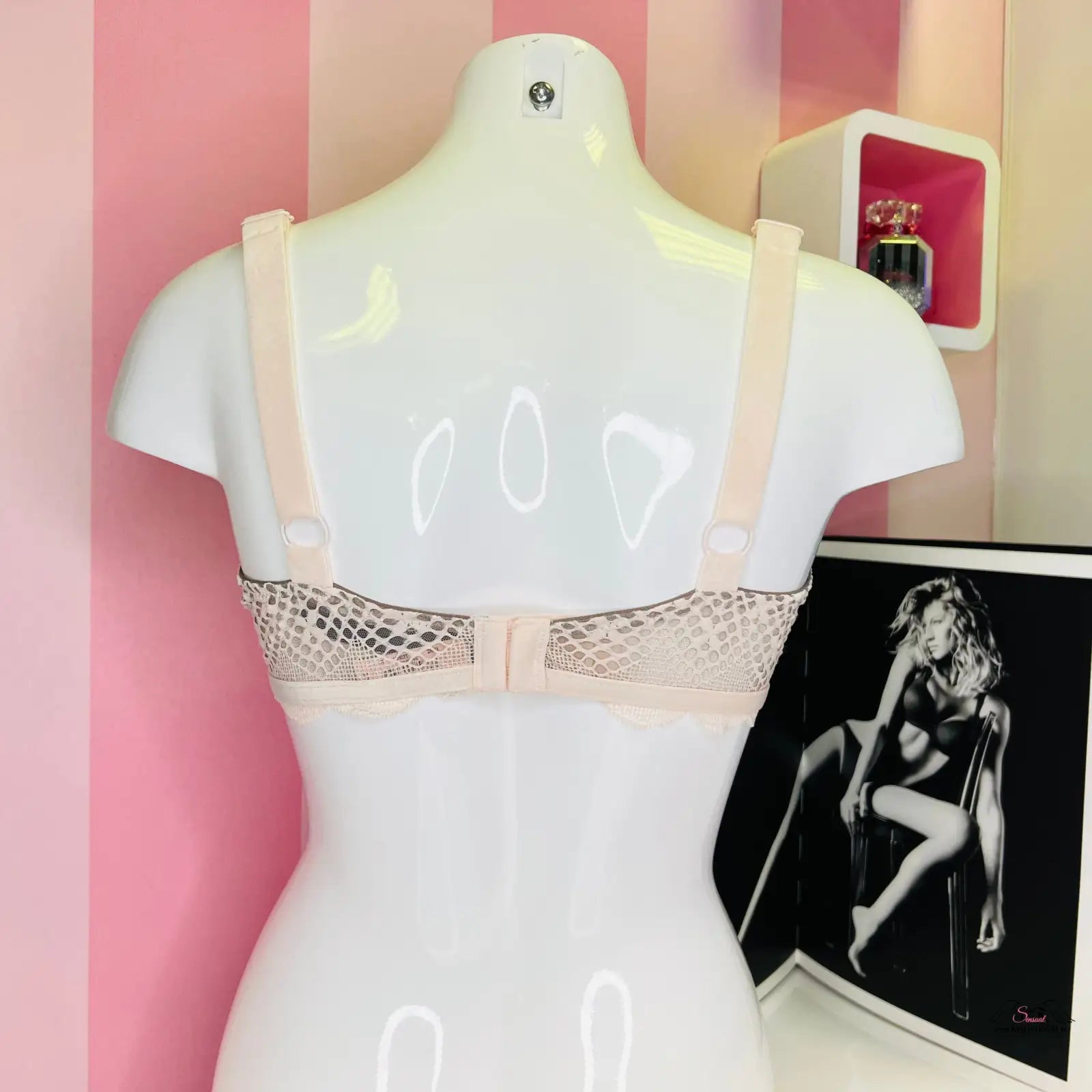Manekýn s krajkovou podprsenkou od Victoria’s Secret před růžovo-bílou stěnou