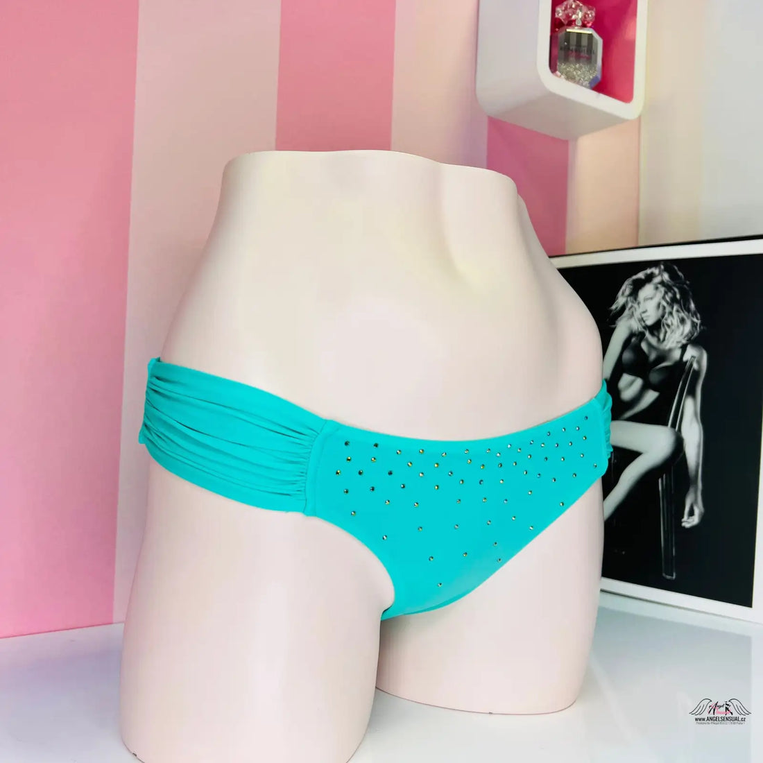 Turquoise bikini bottom with rhinestone details displayed on a mannequin form