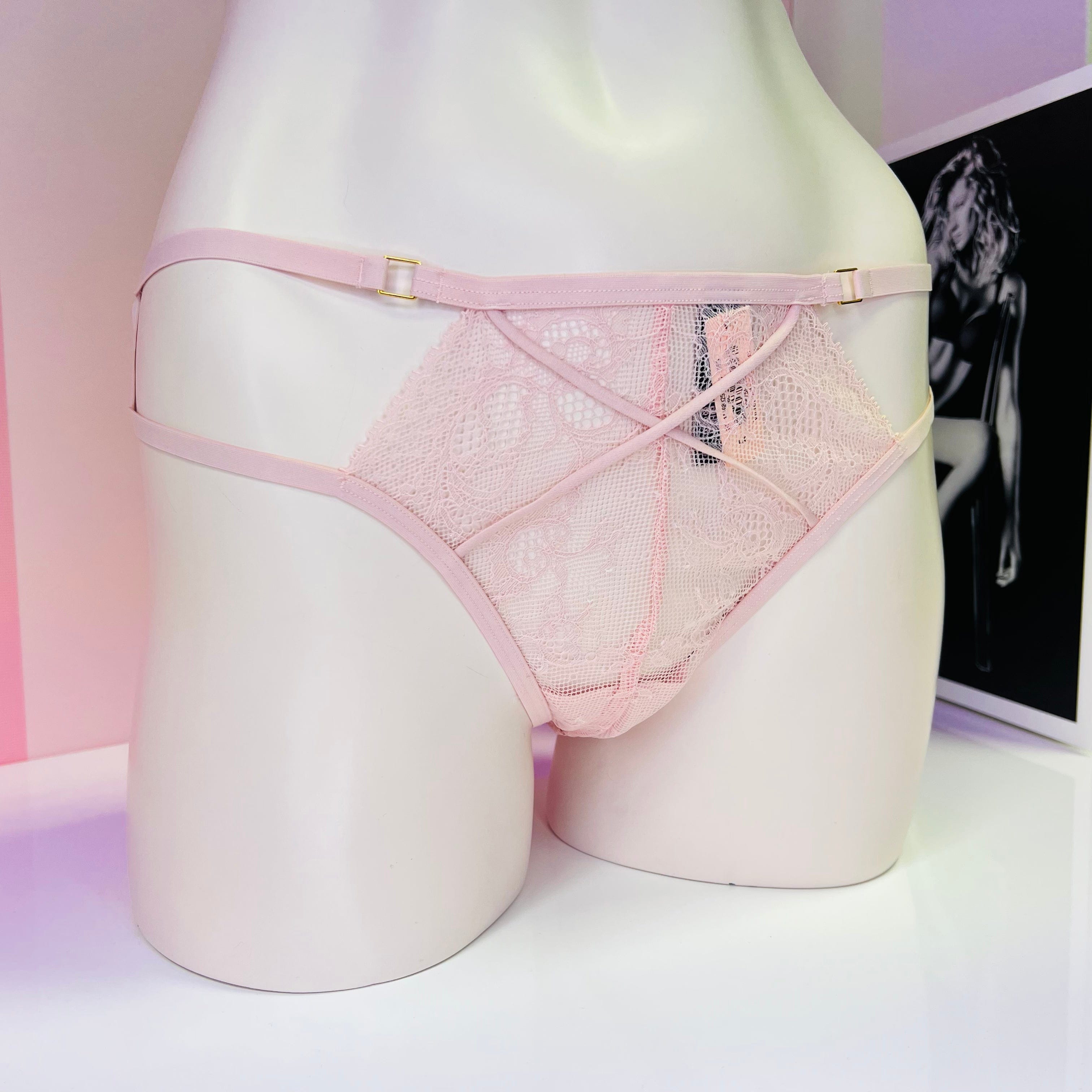 Pink lace and mesh underwear displayed on mannequin form for Victoria’s Secret Strappy Tanga