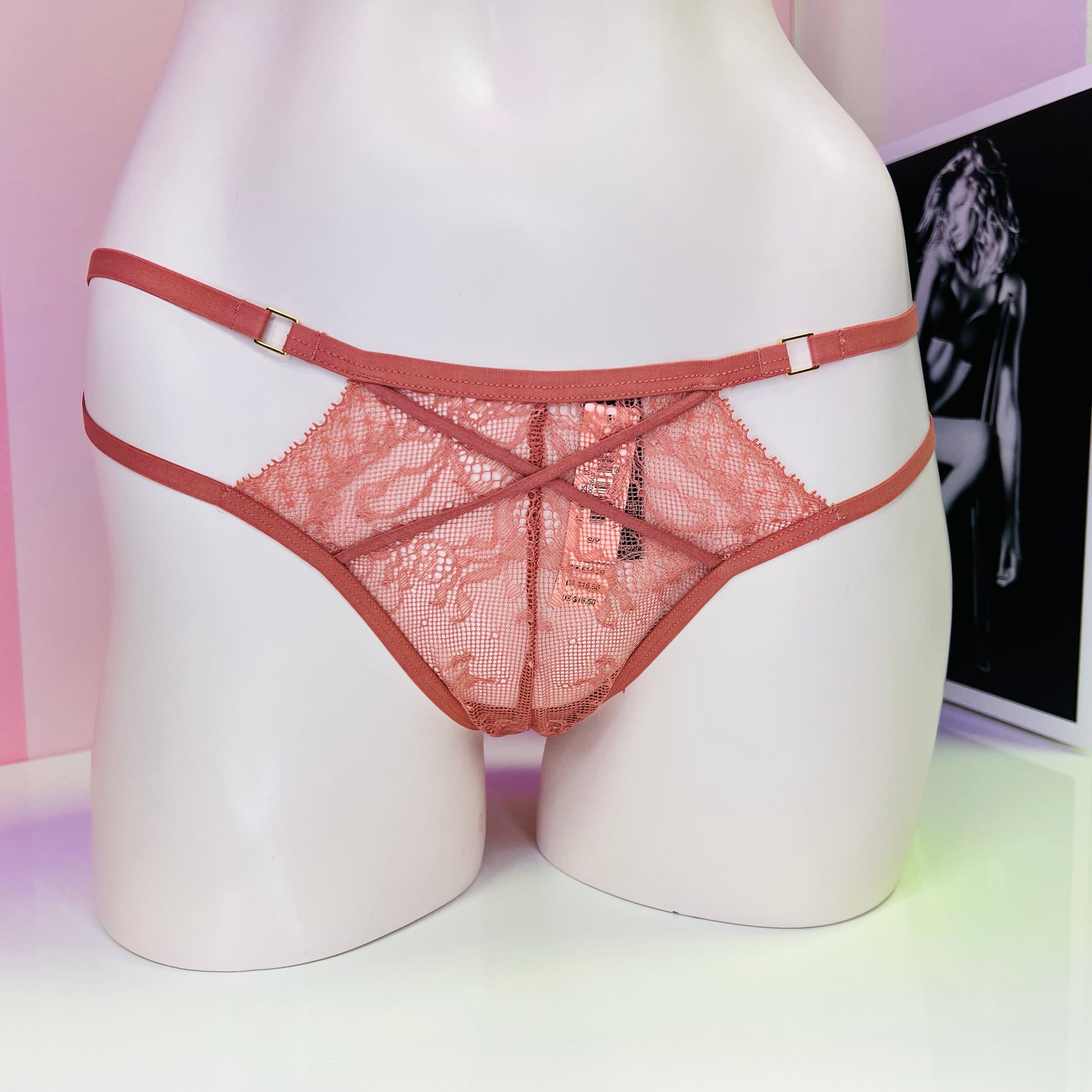 Pink lace and mesh panties on mannequin form for Victoria’s Secret Strappy Tanga