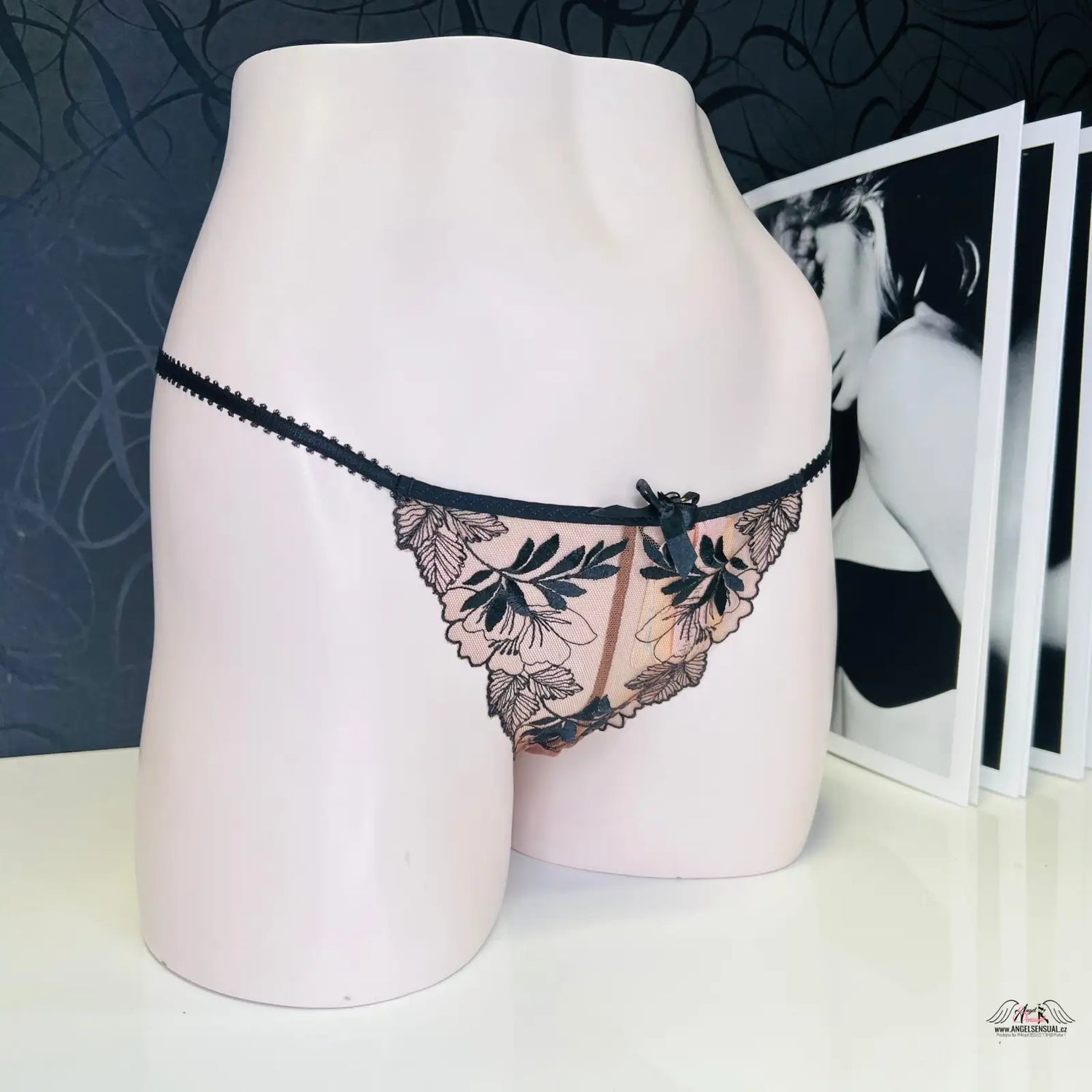 Delikátní černé krajkové tanga na světlém růžovém manekýnu pro elegantní styl