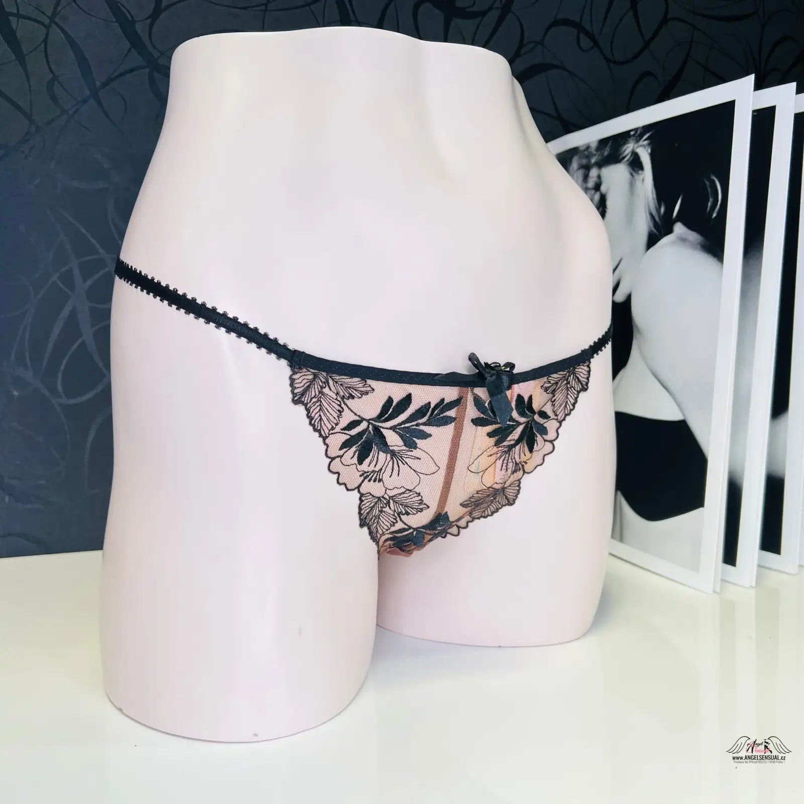 Delikátní černé krajkové tanga na světlém růžovém manekýnu pro elegantní styl
