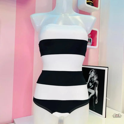 Černobílé pruhované bezramínkové plavky na torzu manekýna v elegantním stylu