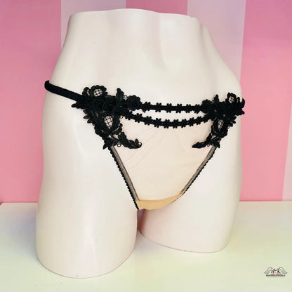 Černé krajkové a žluté tangá na světle růžovém figuríně pro elegantní vzhled