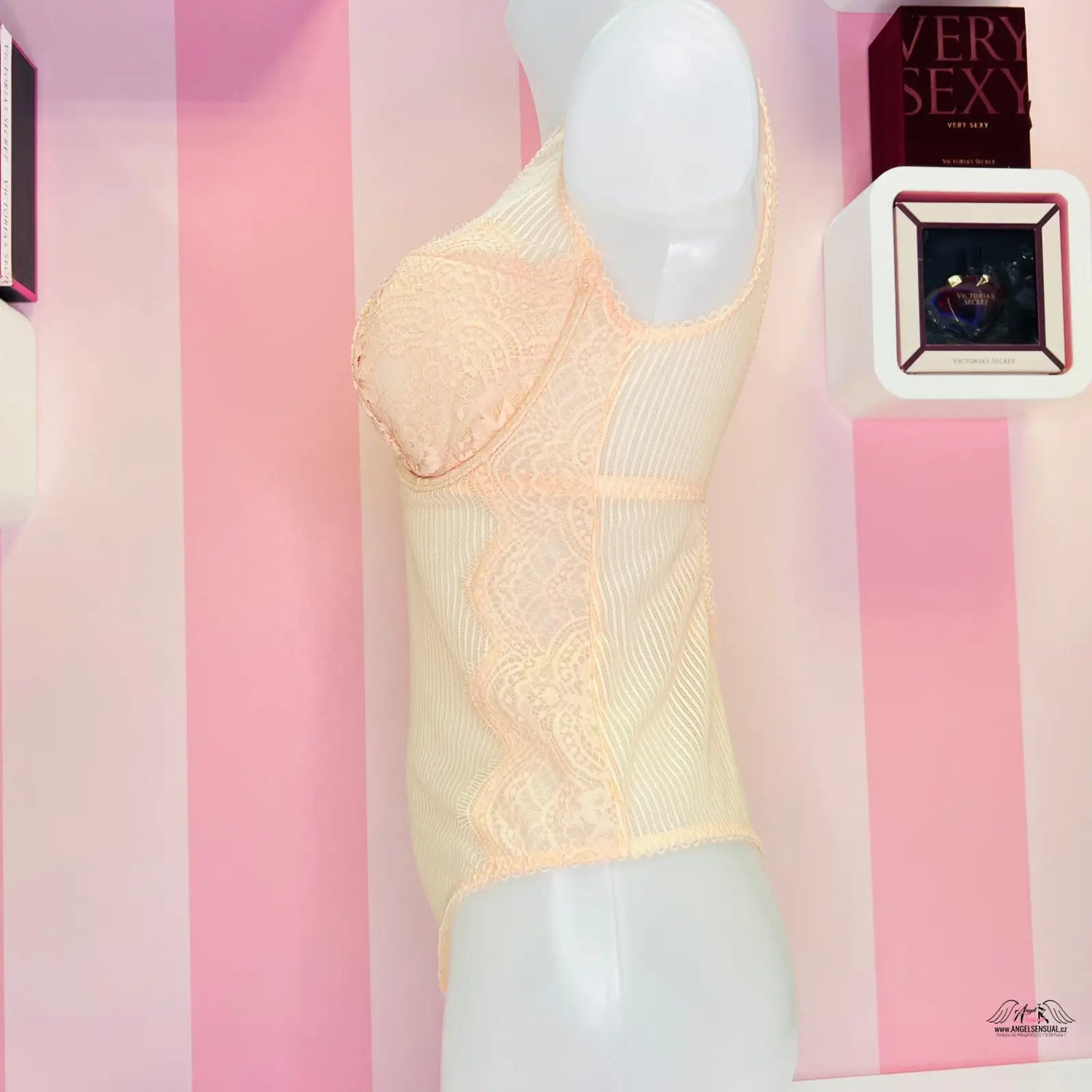 Elegantní krajkové body Victoria’s Secret v peachové barvě na bílém figuríně