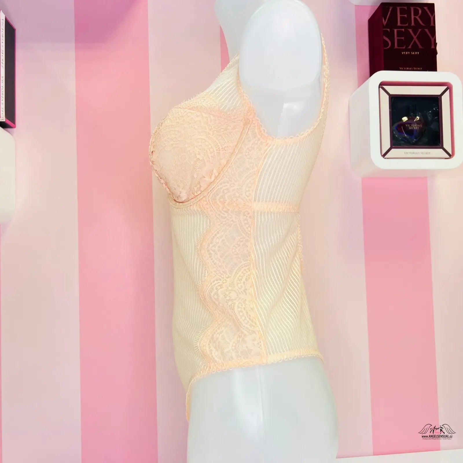 Elegantní krajkové body Victoria’s Secret v peachové barvě na bílém figuríně