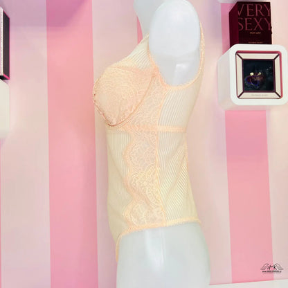 Elegantní krajkové body Victoria’s Secret v peachové barvě na bílém figuríně