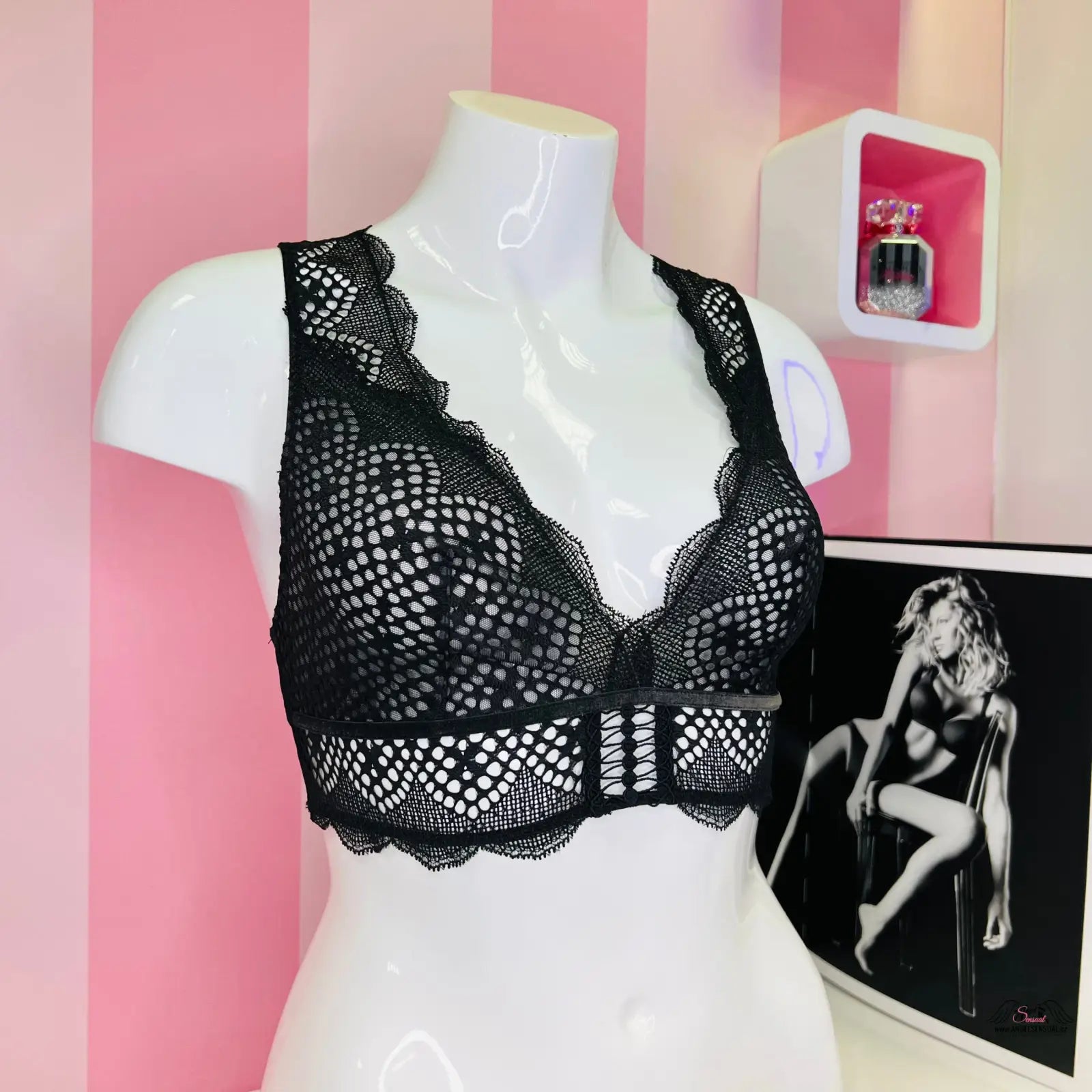 Arafovaný model s černou braletkou a růžovou pruhovanou stěnou, velmi sexy bralette Victoria’s Secret
