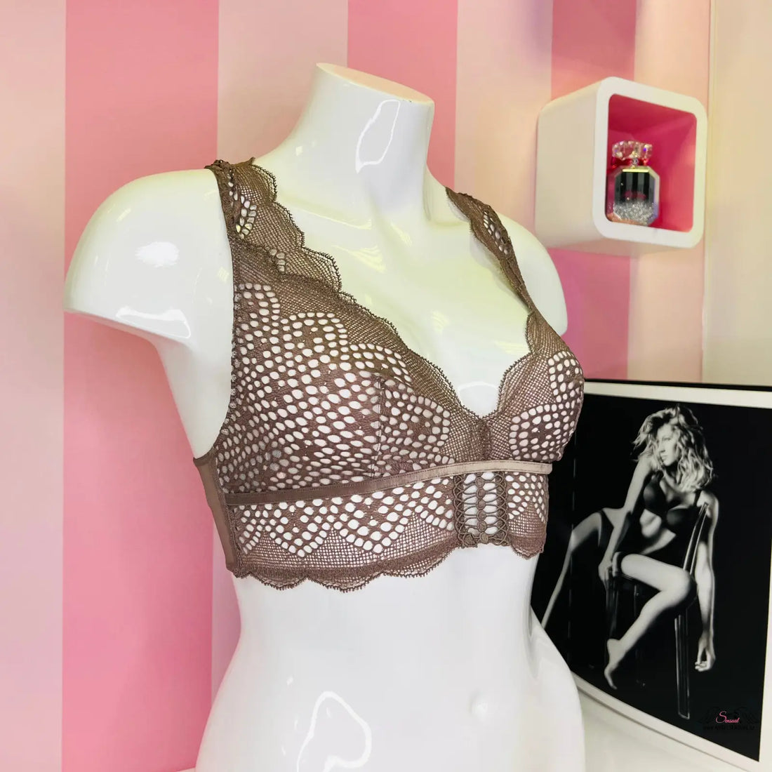 Arafovaný manekýn s velmi sexy bralette Victoria’s Secret na růžové pruhované stěně