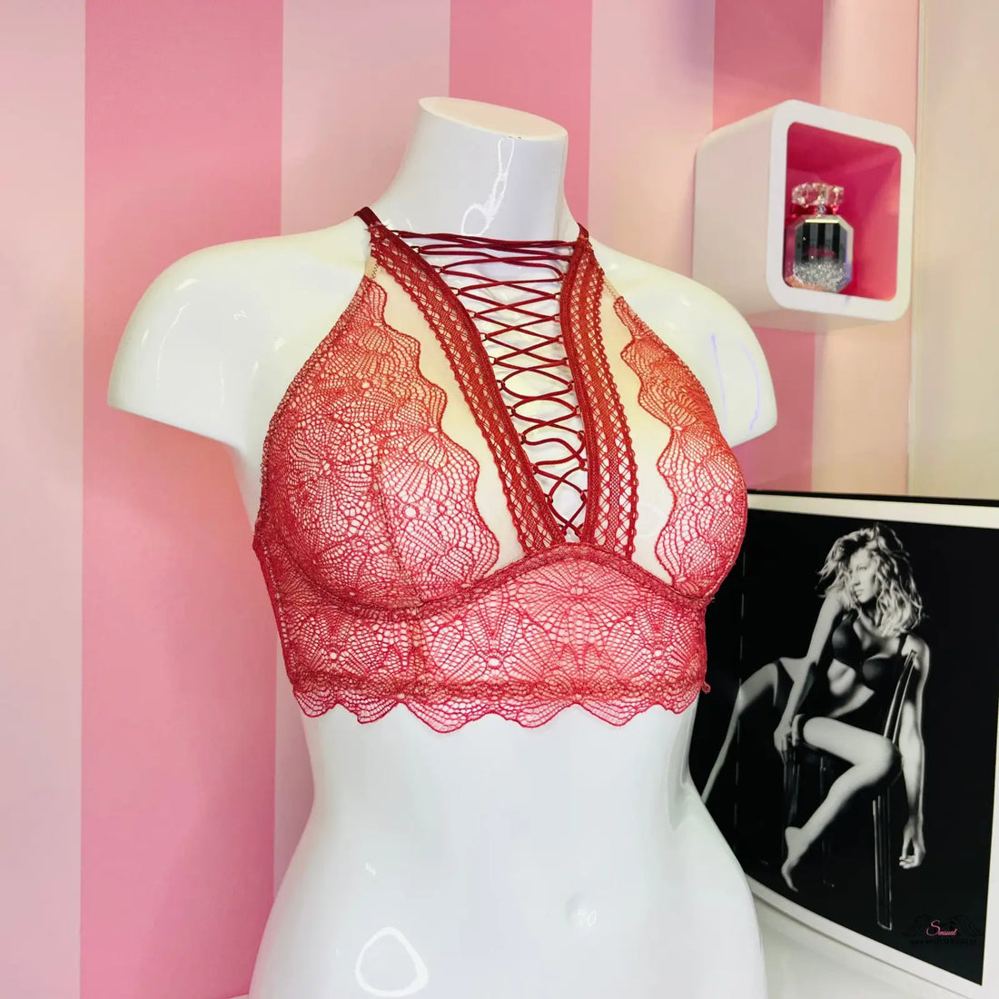Detailní záběr na červenou podprsenku Victoria’s Secret s překříženými ramínky a vyšívanou krajkou