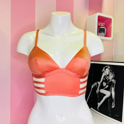 Oranžovo-růžová sportovní nebo plavková podprsenka s pruhovanými bočními panely na bílém modelu, ideální jako měkká strečová bralet