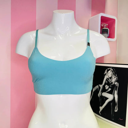 Manekýn s modrou stylovou braletou Victoria’s Secret a růžovo-bílou pruhovanou stěnou