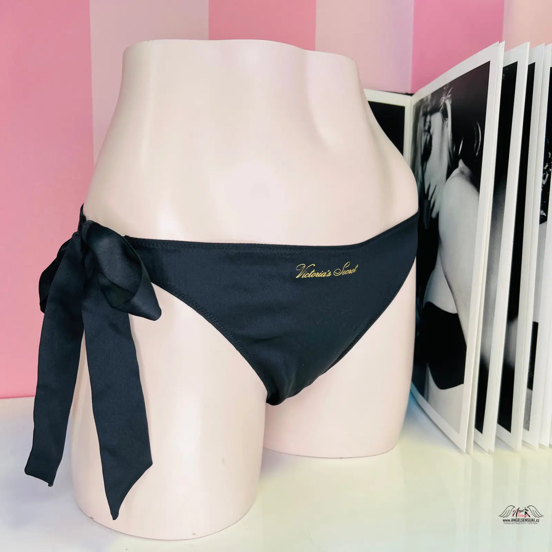 Luxusní string cheeky černou mašlí a zlatým písmem na produktové fotografii