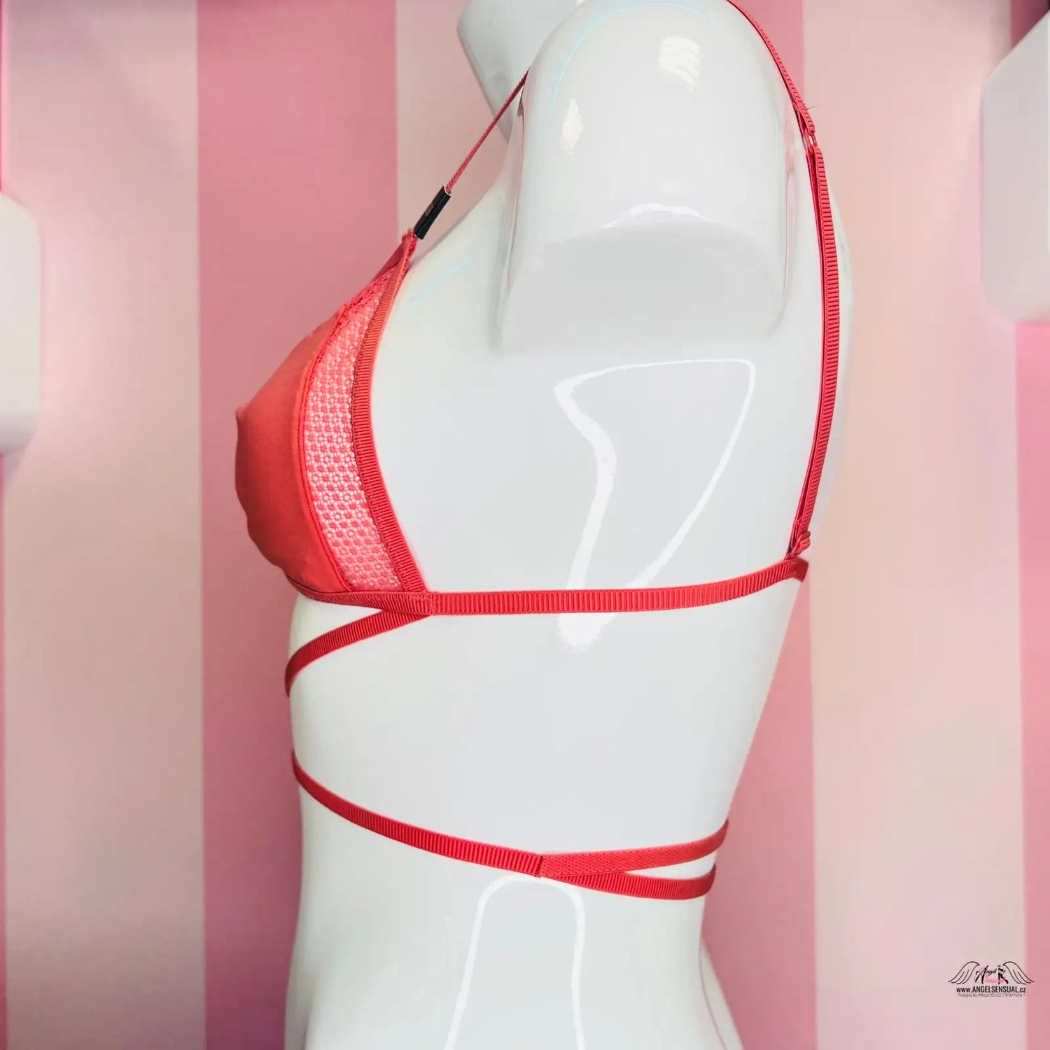 Manekýn s červenou podprsenkou na růžově pruhované stěně Victoria’s Secret