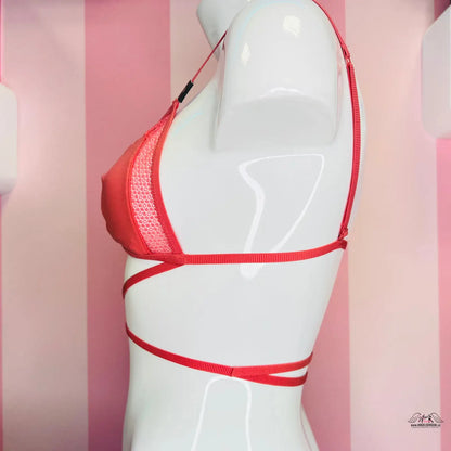 Manekýn s červenou podprsenkou na růžově pruhované stěně Victoria’s Secret