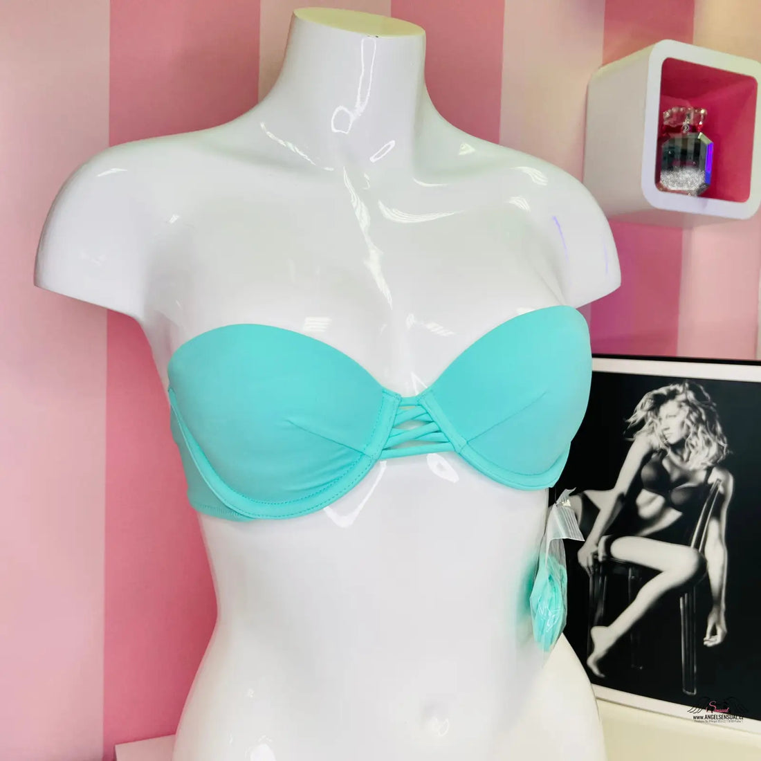 Bílý manekýn s tealovým horním dílem plavek Victoria’s Secret s ozdobnými šňůrkami