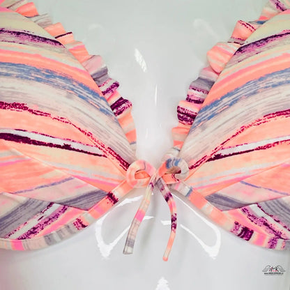 Stylizovaný motýl s pastelově pruhovanými křídly na barevném horním díle plavek Victoria’s Secret