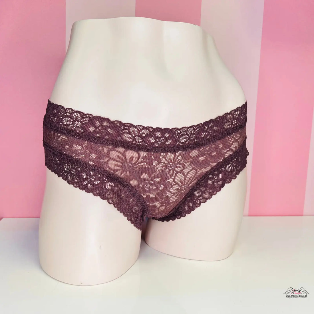 Blízký pohled na dámské cheeky kalhotky Victoria’s Secret s růžovým pruhovaným pozadím