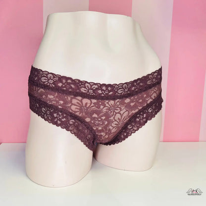 Blízký pohled na dámské cheeky kalhotky Victoria’s Secret s růžovým pruhovaným pozadím