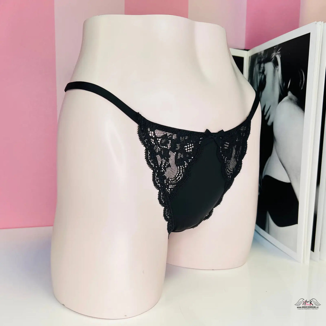 Black lace thong underwear on a pale pink mannequin torso, Victoria’s Secret Krajkové kalhotky