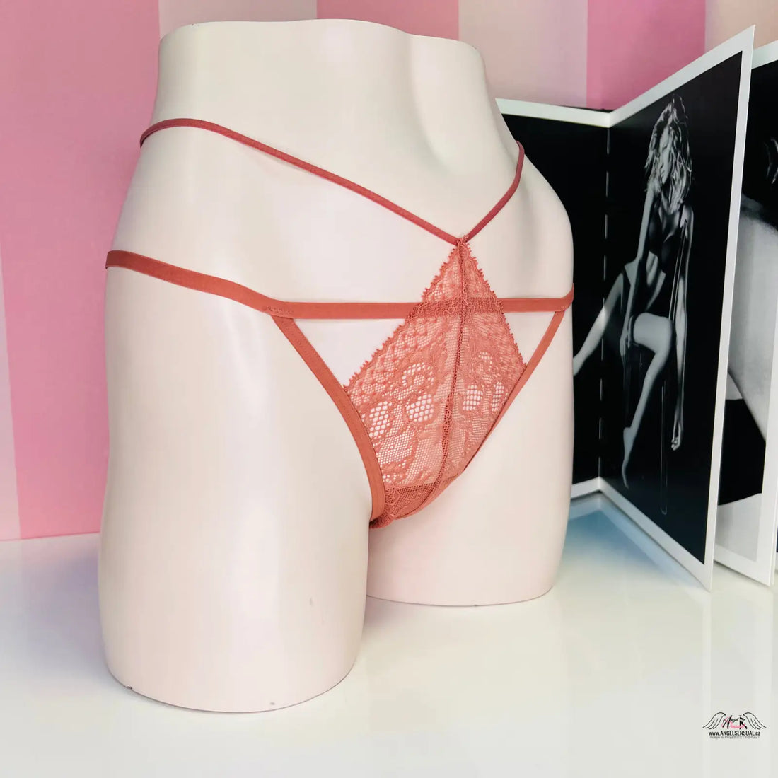 Manekýn dolní část těla v červených krajkových kalhotkách s ozdobnými pásky kolem obvodu