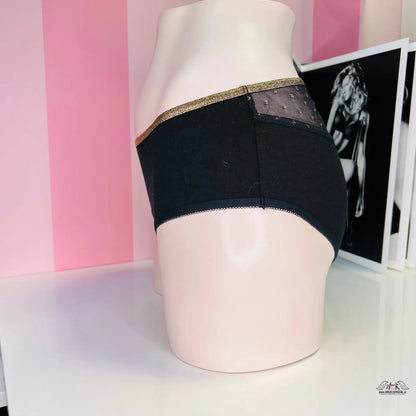 Stylové černé kalhotky s vysokým pasem s zlatým pasem na růžovém modelu