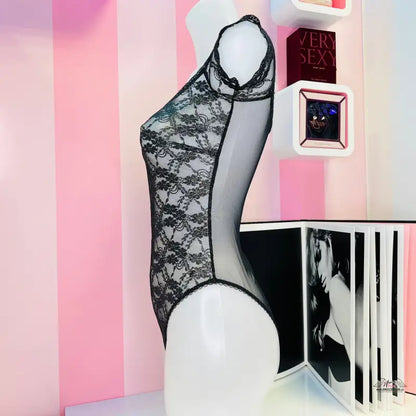 Manekýn v luxusním krajkovém plyšovém body Victoria’s Secret na růžovo-bílé stěně
