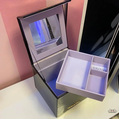 Lesklý úložný box s hodinkami v černou krabičkou a zlatou rukojetí