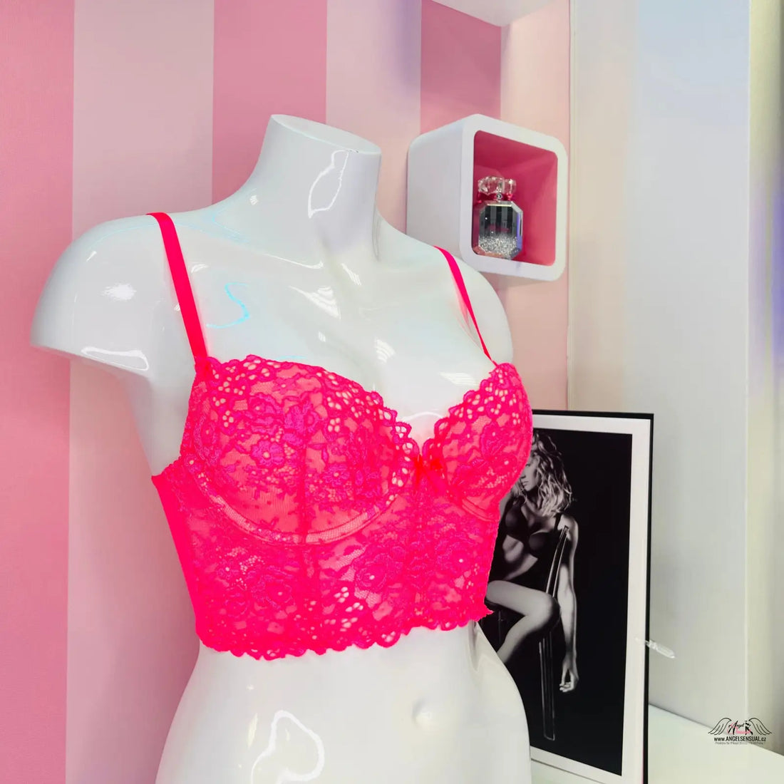 Hot pink krajkový nízký korzet s vyztužením na bílém manekýnu, elegantní krajkový design