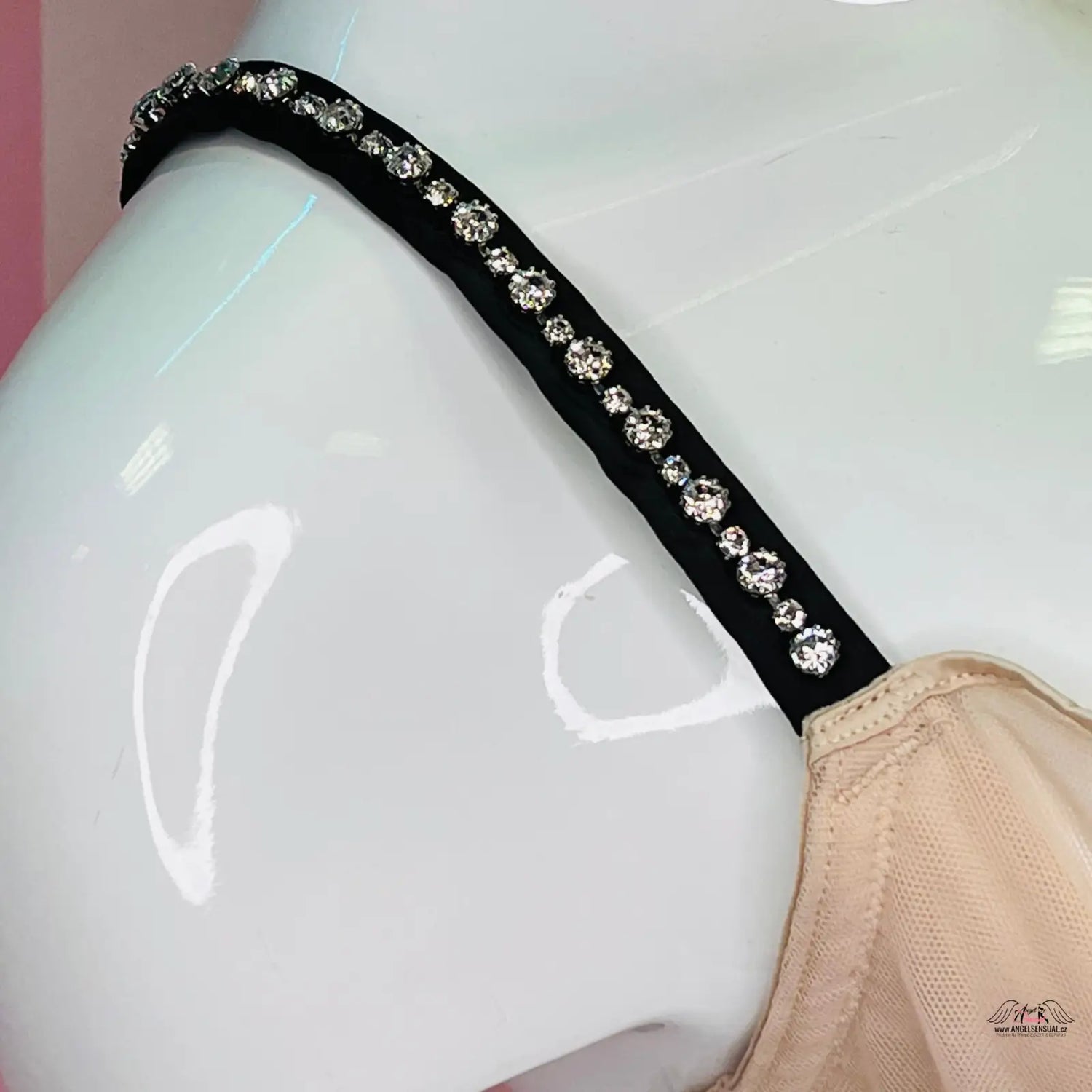 Krásná krémová podprsenka s výraznou mašlí uprostřed a rhinestone-studded strap