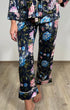 Žena v květinovým potiskem velvet lurex pyžamových kalhotách na dřevěné podlaze