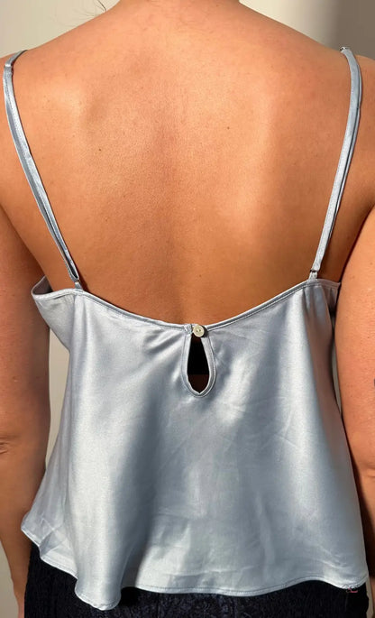 Žena v saténovém pyžamovém topu Victoria’s Secret s černou krajkovou sukni, stylovou noc