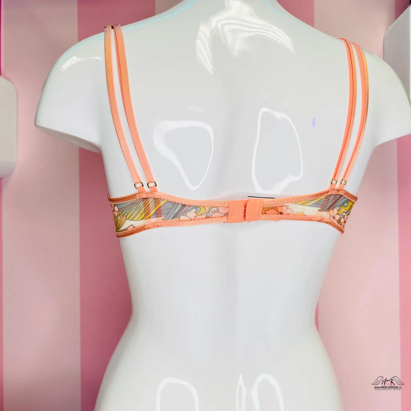 Manekýn s černou podprsenkou před růžovými pruhy v obchodě Victoria’s Secret
