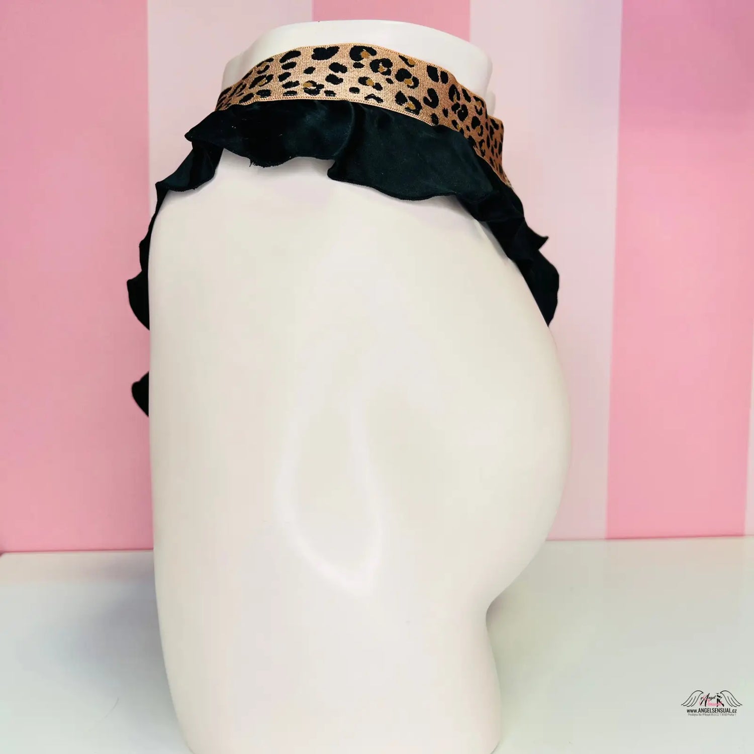 Bílá manekýnská hlava s leopardím a černým ruffled headbandem, ideální pro hedvábné tanga s vysokým pasem a maximálním pohodlím