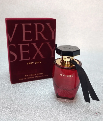 Červená parfémová láhev s černou stuhou pro Victoria’s Secret Very Sexy s divokou ostružinou